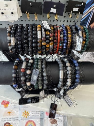 Een verzameling armbanden van kralen in verschillende kleuren en stijlen.
